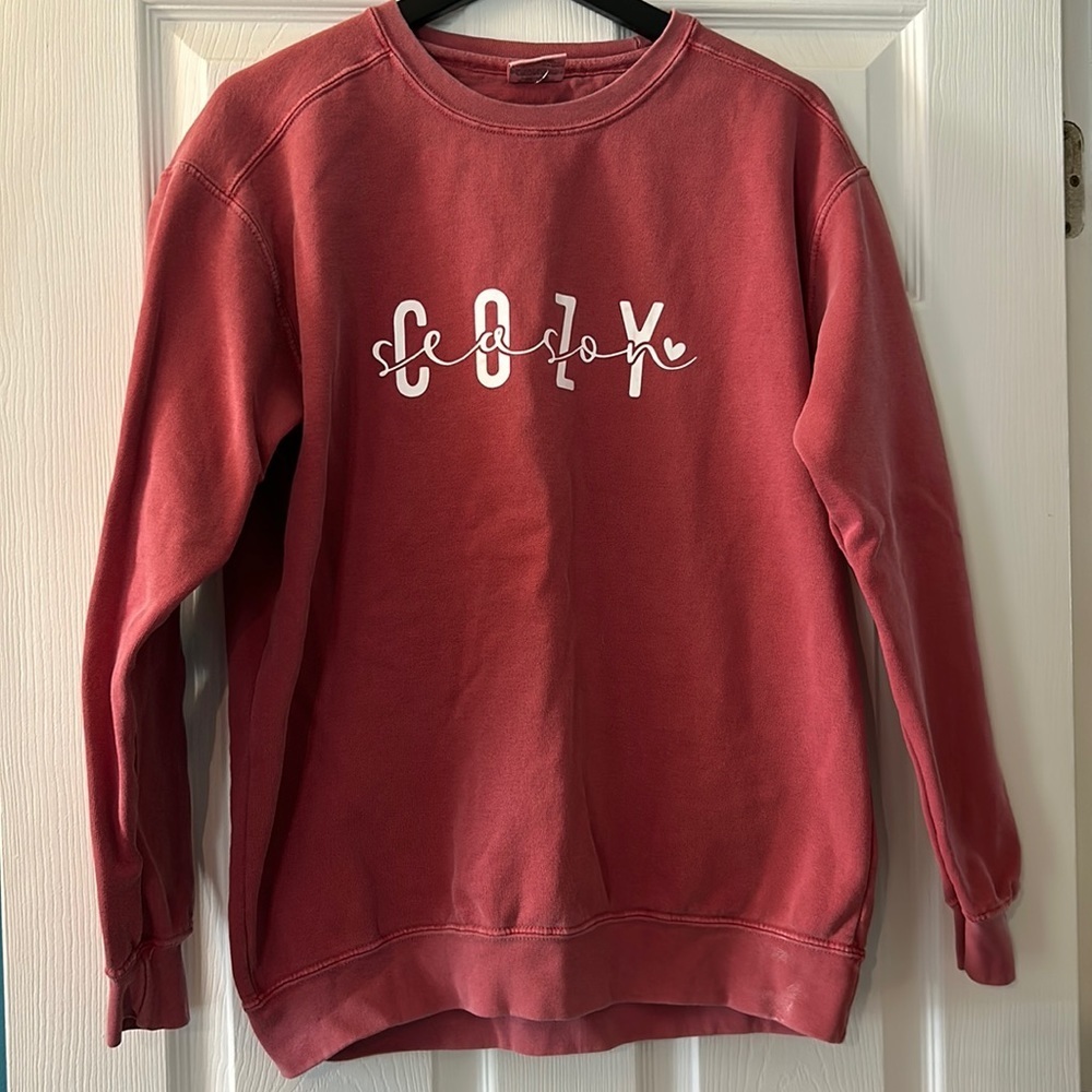 Pink sweatshirt with “Cozy Season” on front